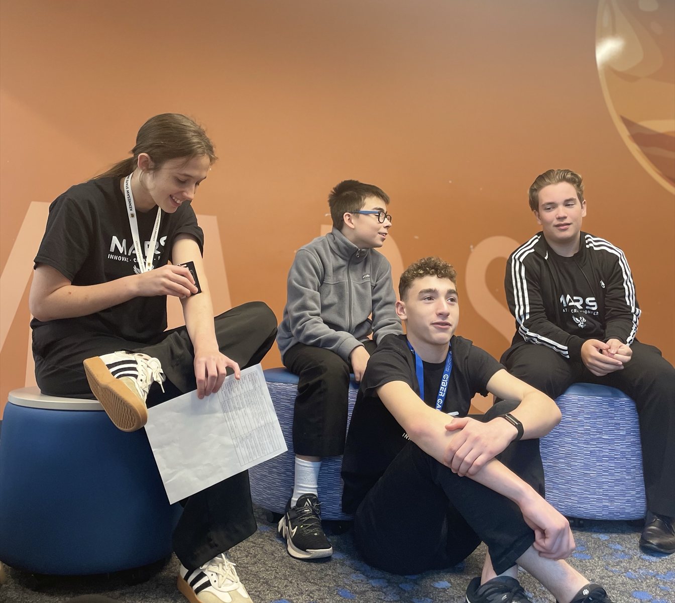 Four MARS students talking and smiling together on campus.